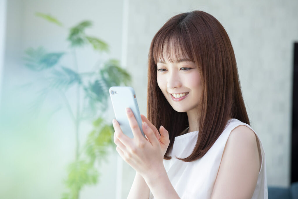 スマホ操作をしている女性の画像
